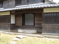 旧早川家住宅の外回りの一角に石段が置いてある場所の写真