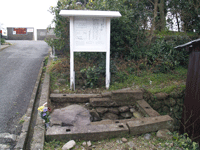 横津の石槨の前に立つ説明版の写真