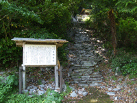 善納岩陰の説明版と山道の写真