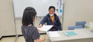 小学生が地域の方に教わりながら学習を進めています。