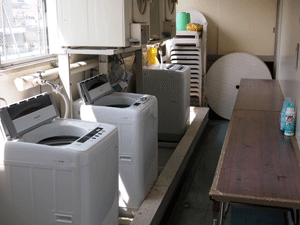 ４階の洗濯室の洗濯機３台と乾燥機２台を写した写真