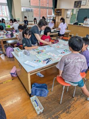 地域の方と一緒に絵葉書を描く子どもたち