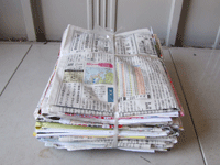 新聞と折込みチラシをいっしょに縛っている物を写した写真
